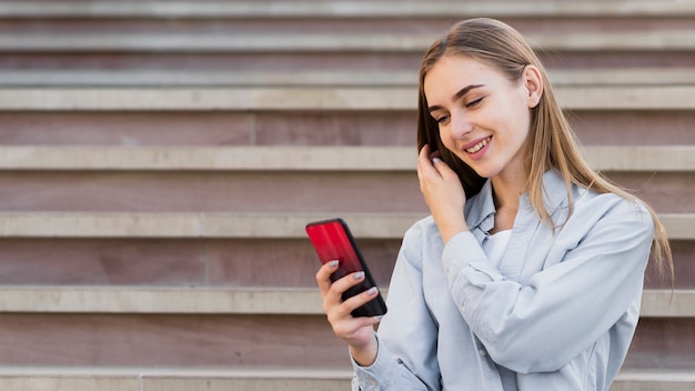 Medium shoot blonde woman looking on phone