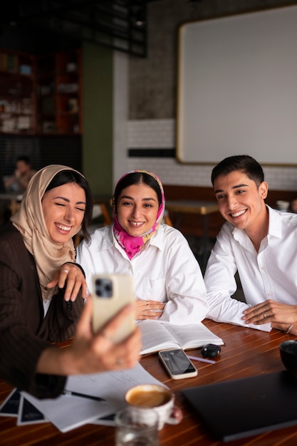 Medium shot arab friends taking selfie