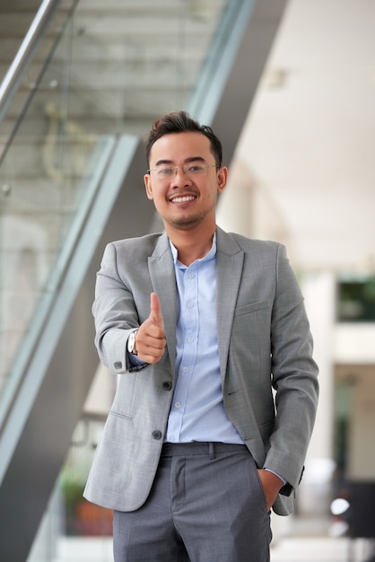 Medium shot of Asian man giving a thumbs up gesture to the camera