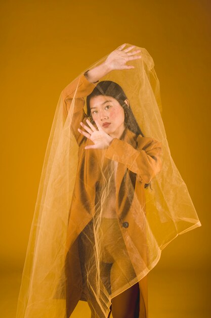 Medium shot asian model posing with yellow background