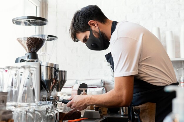 Medium shot barista wearing mask