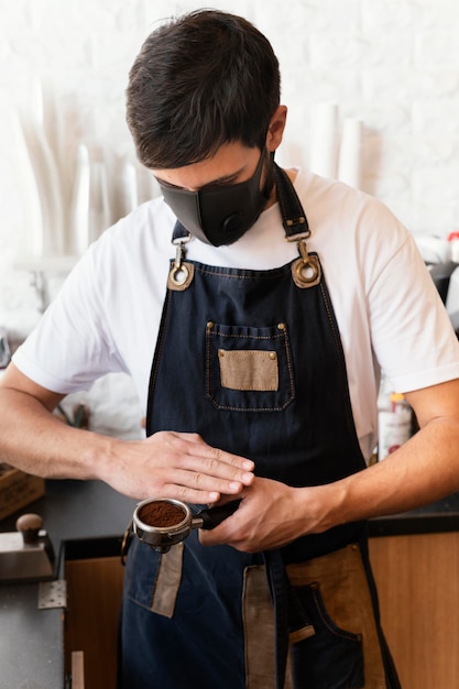 Medium shot barista with mask working