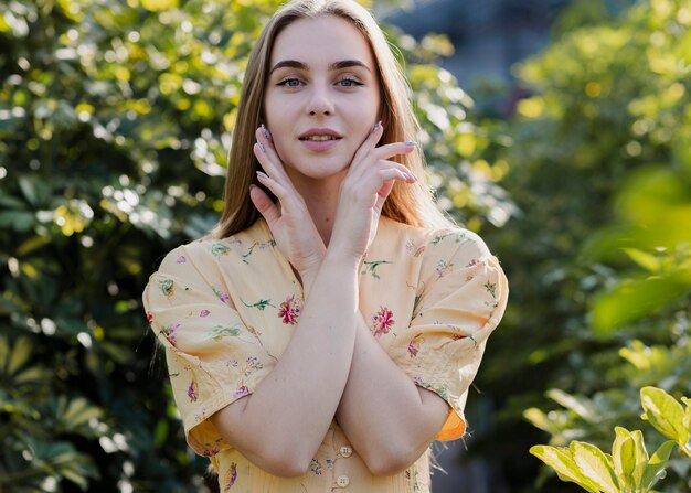 Medium shot of beautiful woman holding her hands on her face