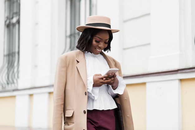 Medium shot beautiful woman looking on her phone