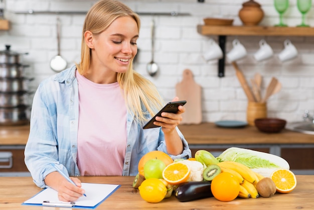 Medium shot blonde girl with smartphone