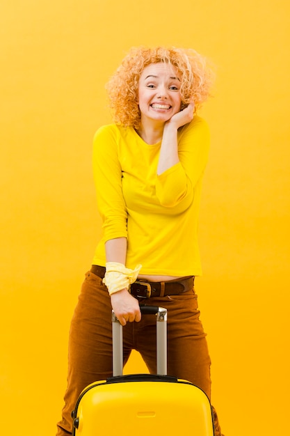 Medium shot of blonde woman with suitcase