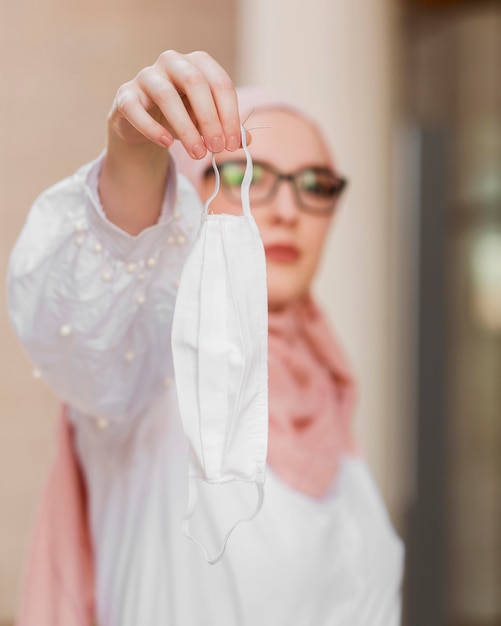 Free photo medium shot blurred woman holding mask