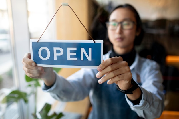 Free Photo medium shot blurry man arranging open sign