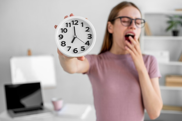 Free photo medium shot blurry woman holding clock