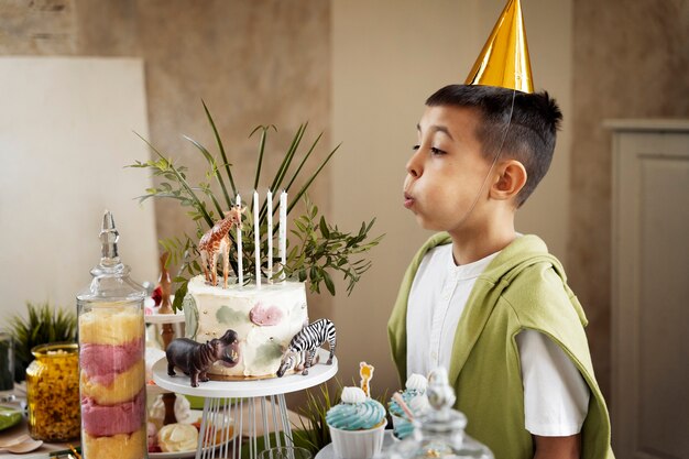 Medium shot boy blowing candles