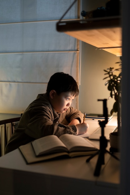 Free photo medium shot boy doing homework