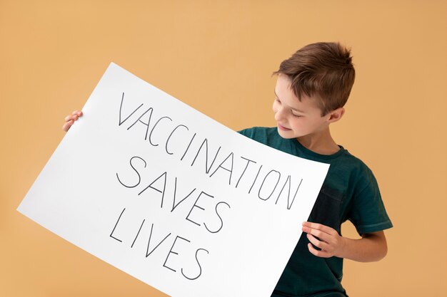 Medium shot boy holding placard with message