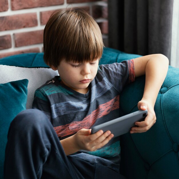 Medium shot boy holding smartphone