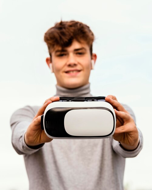 Free photo medium shot boy holding virtual reality glasses