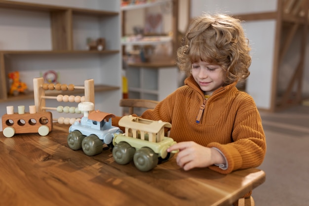 Free Photo medium shot boy playing with ecological toys