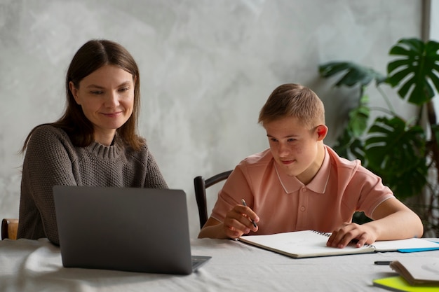 Medium shot boy and woman with laptop