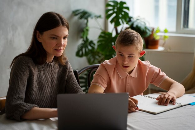 Medium shot boy and woman with laptop