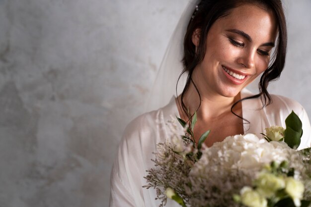 Medium shot bride posing with flowers