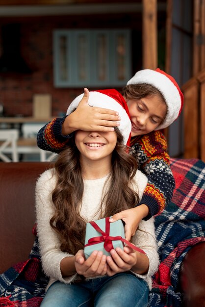 Medium shot brother surprising sister with gift