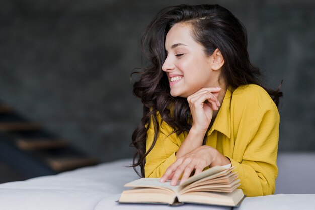 Medium shot brunette happy woman with book