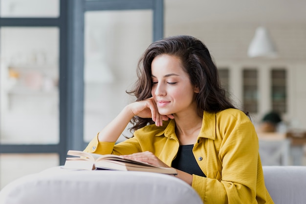 Free photo medium shot brunette woman reading indoors