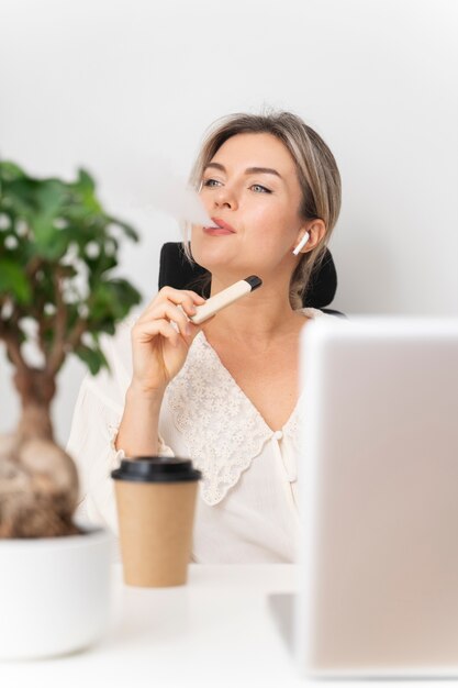 Medium shot business woman vaping