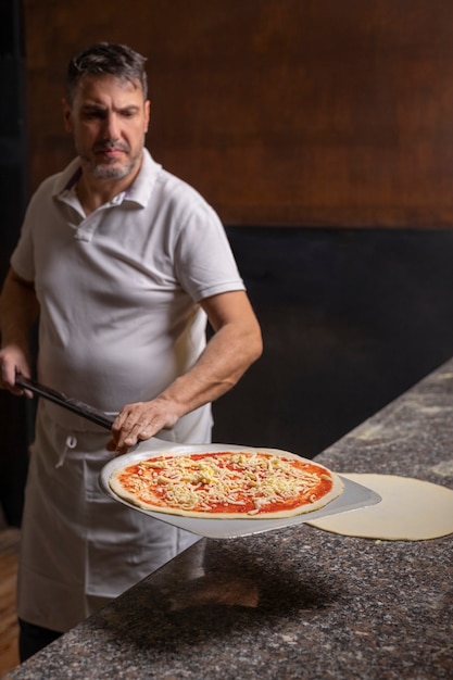 Medium shot chef preparing pizza