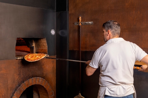 Free photo medium shot chef preparing pizza