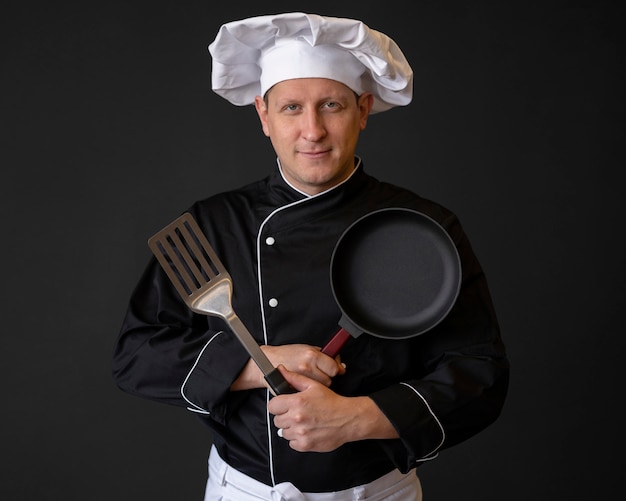 Medium shot chef with pan and spatula