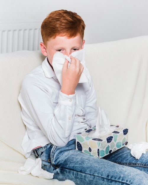 Medium shot child blowing his nose 