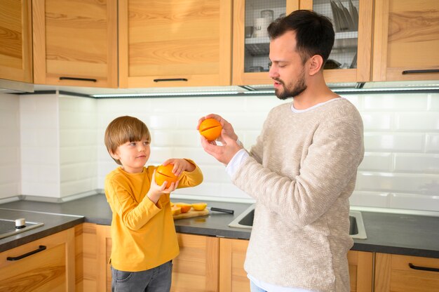 Medium shot of child and father in the kitchen