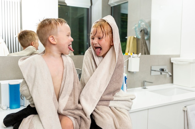 Free Photo medium shot children sitting in the bathroom