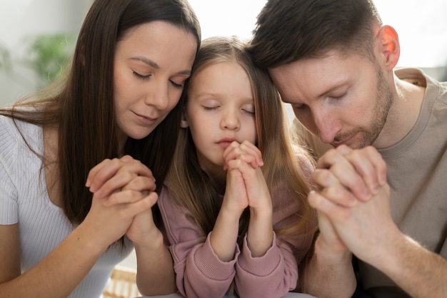 Free Photo medium shot christian family praying together