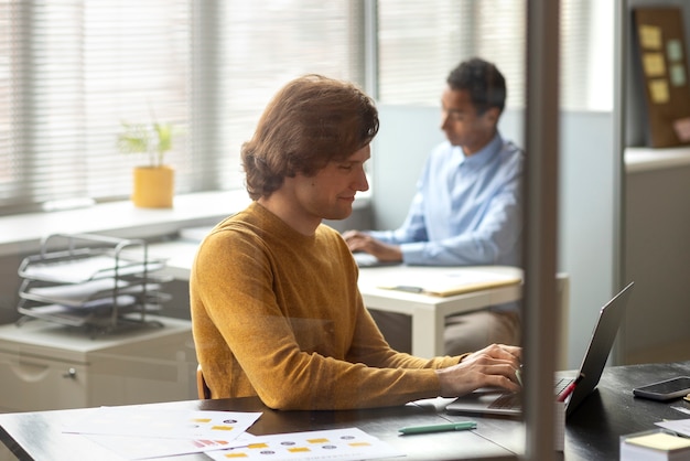 Medium shot colleagues working at office