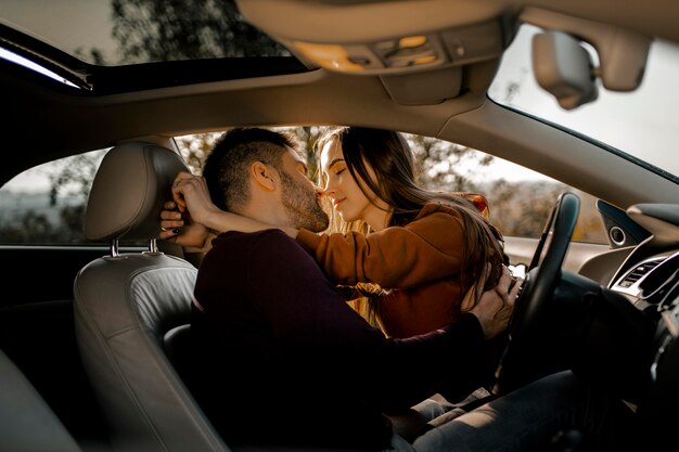 Medium shot couple being romantic in car