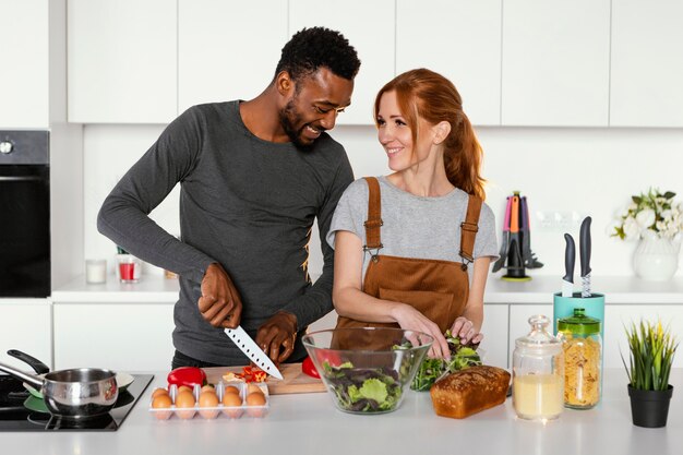 Medium shot couple cooking together