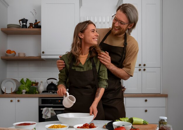 Medium shot couple cooking together