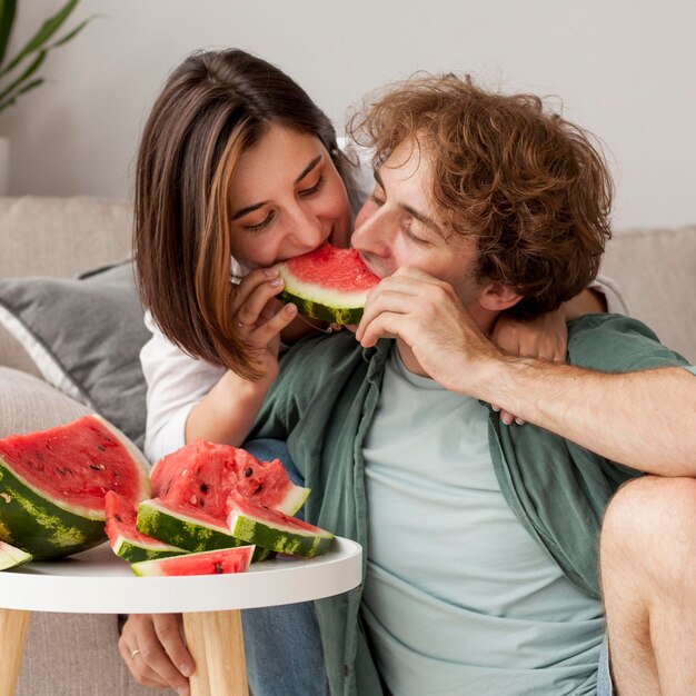 Medium shot couple eating watermelon