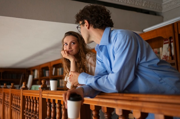 Medium shot couple having a bookstore date