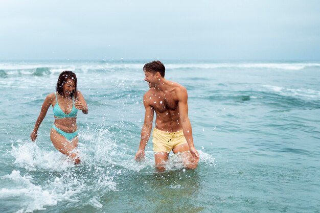 Medium shot couple having fun at seaside