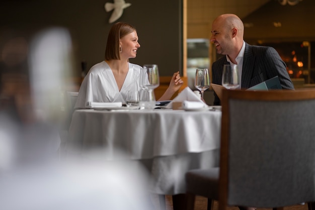 Free Photo medium shot couple having  lunch in luxury restaurant