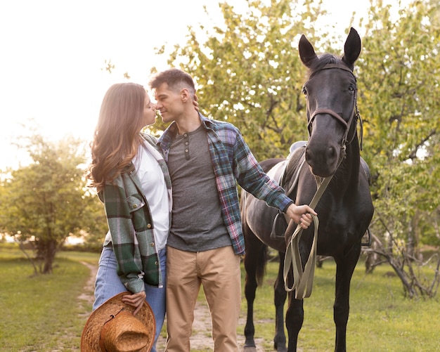 Medium shot couple and horse