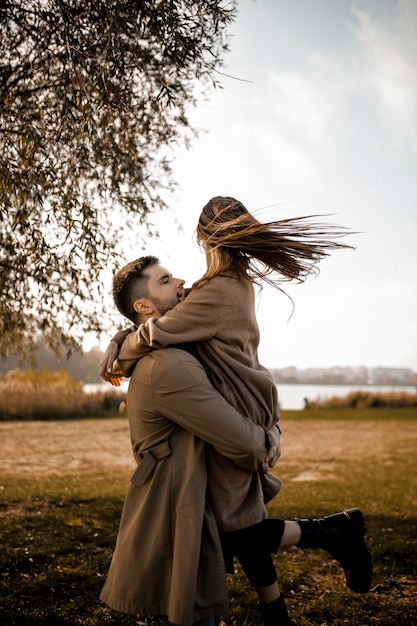 Free photo medium shot couple hugging outdoors