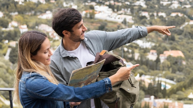 Free Photo medium shot couple pointing at town