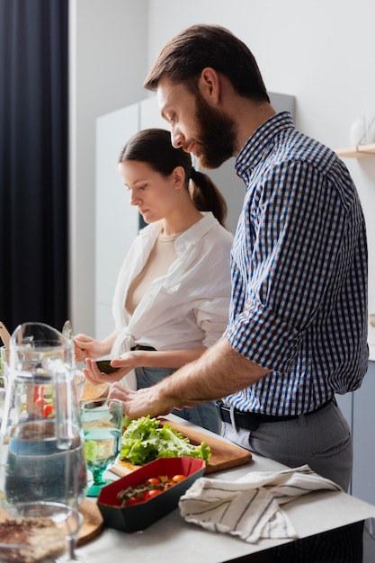 Free photo medium shot couple preparing food at home