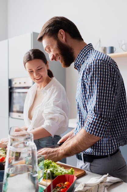 Medium shot couple preparing food together