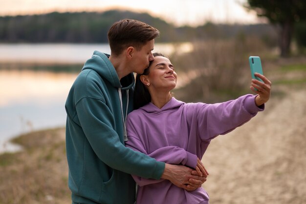 Medium shot couple taking selfie