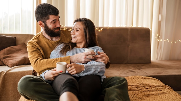 Medium shot couple with coffee cups