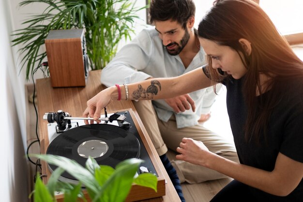 Medium shot couple with vinyl disc at home