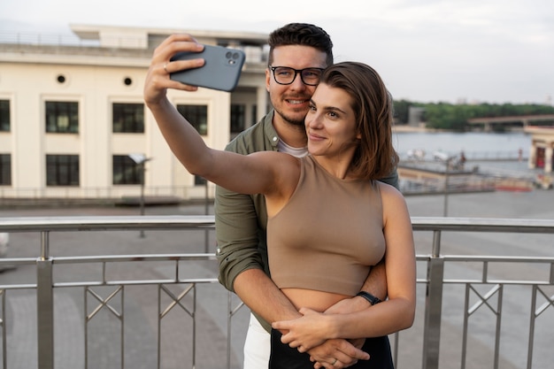 Medium shot cute couple taking selfie